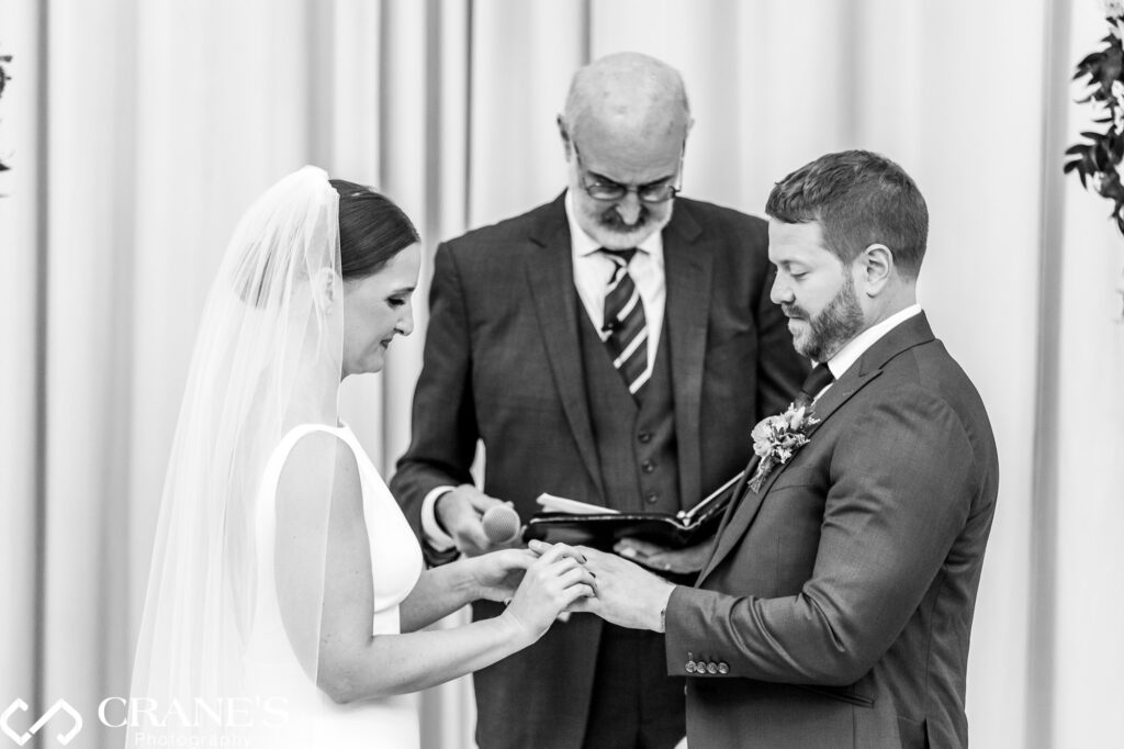 A bride and groom exchange wedding bands during their ceremony at Artifact Events' North Atrium.