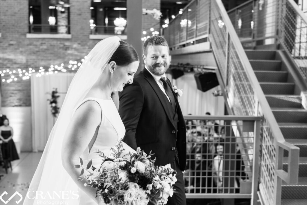 Kevin and Liz walked down the aisle at the North Atrium in Artifact Events, smiling.