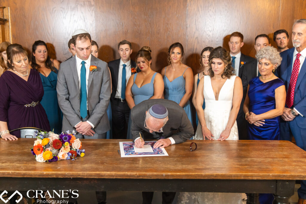 Signing a ketubah during a wedding at Artifact Events, a meaningful Jewish tradition.