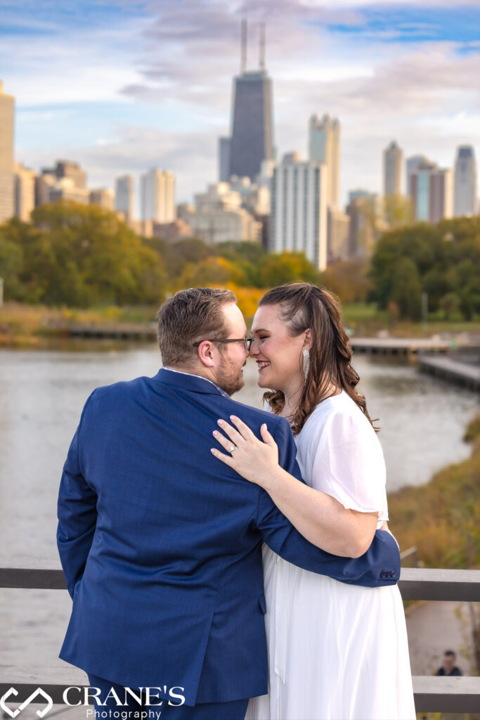 Fun engagement session image on the bridge at Lincoln Park with magnificent views of the city of Chicago in the background.