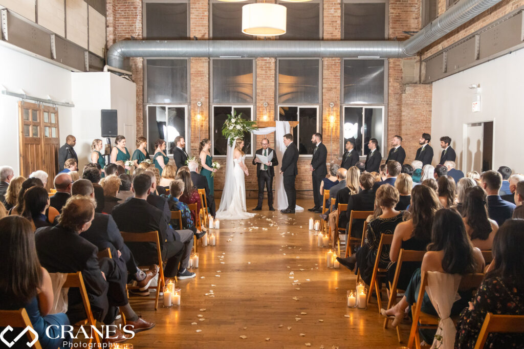 A wide-angle view captures the enchanting atmosphere of a wedding ceremony at City View Loft, showcasing the venue and the joyous celebration.