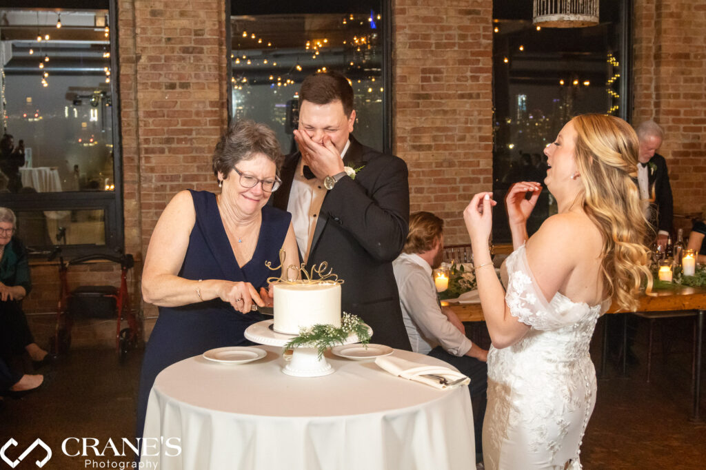 The bride and groom share a sweet moment as they cut their wedding cake at City View Loft, marking the beginning of their delightful journey together.