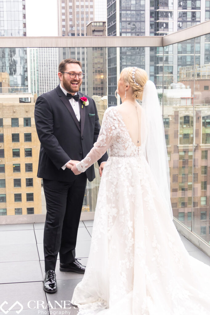 Against the backdrop of towering city buildings on the rooftop of theWit Hotel, the bride and groom share a deeply emotional 'first look' moment, setting the stage for the love and anticipation that will color their wedding day.