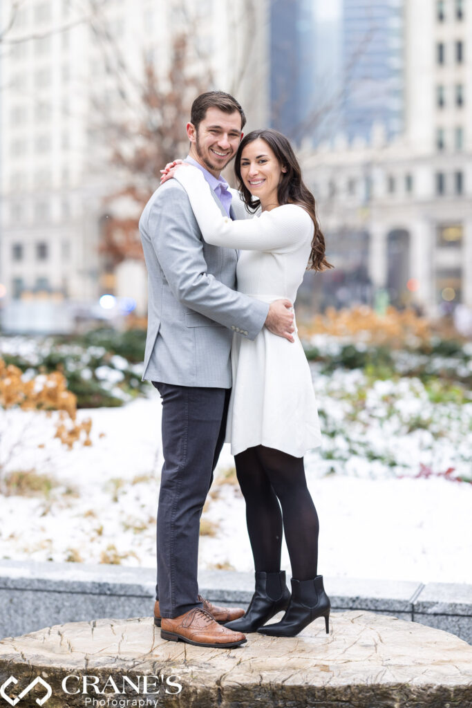A engaged couple poses amidst the snow-covered charm of downtown Chicago for their engagement photos, capturing the magic of love against the wintry urban backdrop.