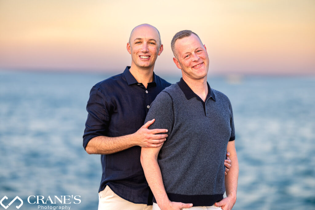 An elegant engagement portrait of an LGBTQ+ couple in Chicago, captured at sunset with Lake Michigan in the background.