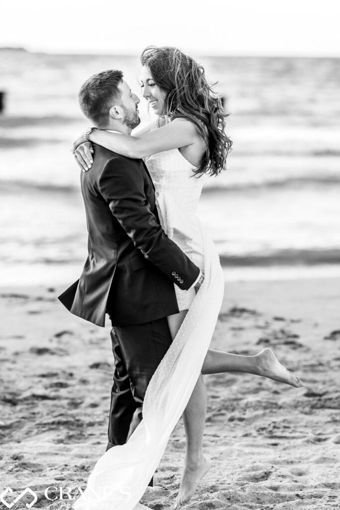 North Avenue Beach provides a breathtaking backdrop for an intimate engagement photo. The man scoops up his fiance in a joyful embrace, capturing their love story.