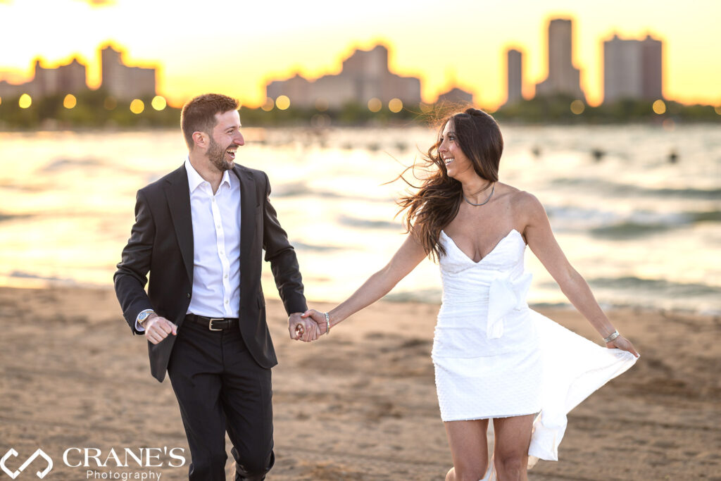 Engagement photo at North Avenue Beach of a couple running on the sand.