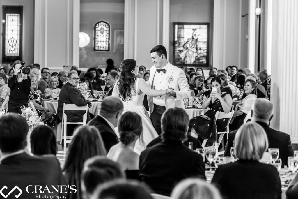 The bride and groom share their first dance in The Chicago Room at the Chicago History Museum. The grand architecture provides a timeless backdrop, enhancing the elegance and romance of the moment.