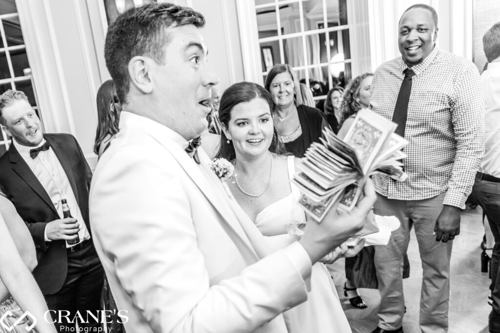 The groom reacts with joy during the dollar dance at the wedding reception held at the Chicago History Museum.