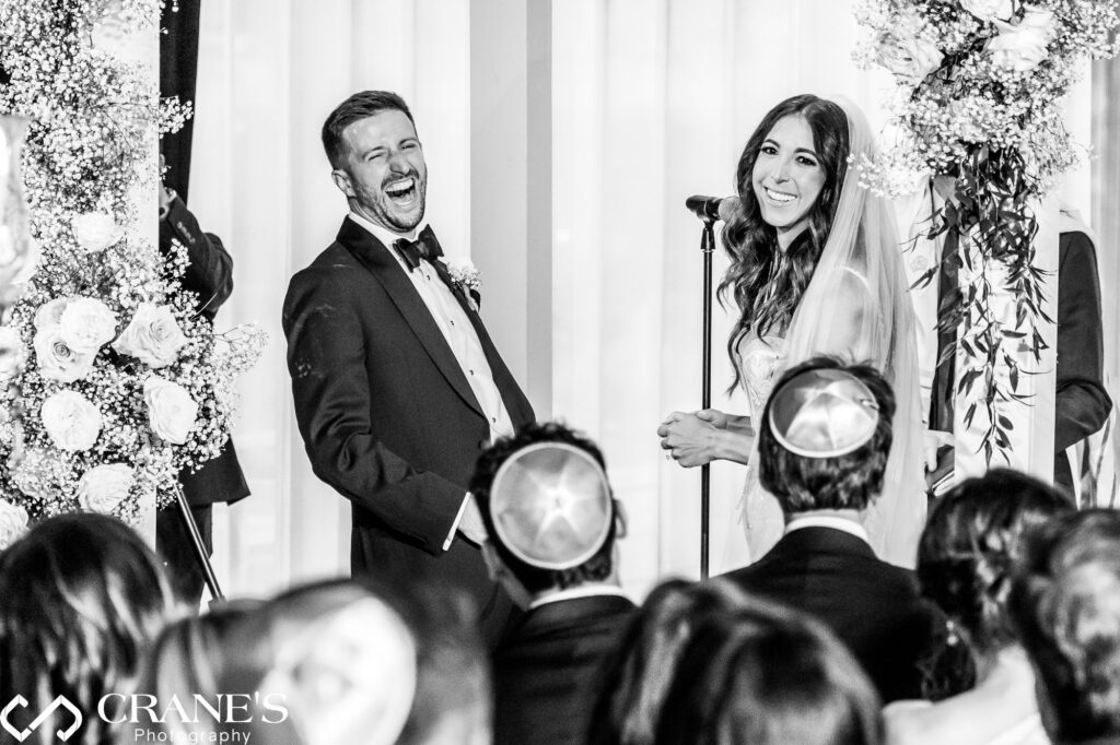 A candid moment during a Jewish wedding ceremony at RPM Events, where the groom is captured with a huge smile as he looks at his family.