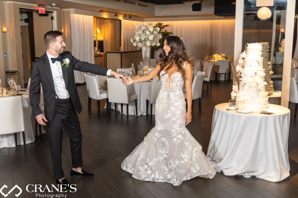 The bride and groom pose proudly with their magnificent cake at their black-tie wedding at RPM Events. 