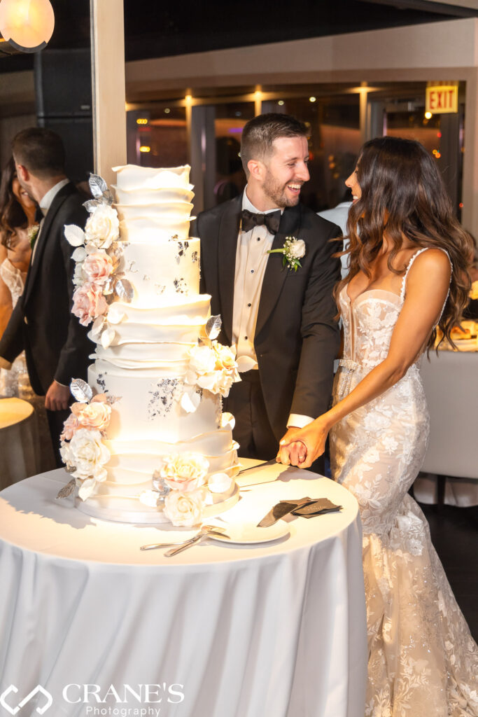 A festive moment at a black-tie wedding reception at RPM: the newlyweds cut a huge wedding cake, symbolizing the sweetness of their new life together.