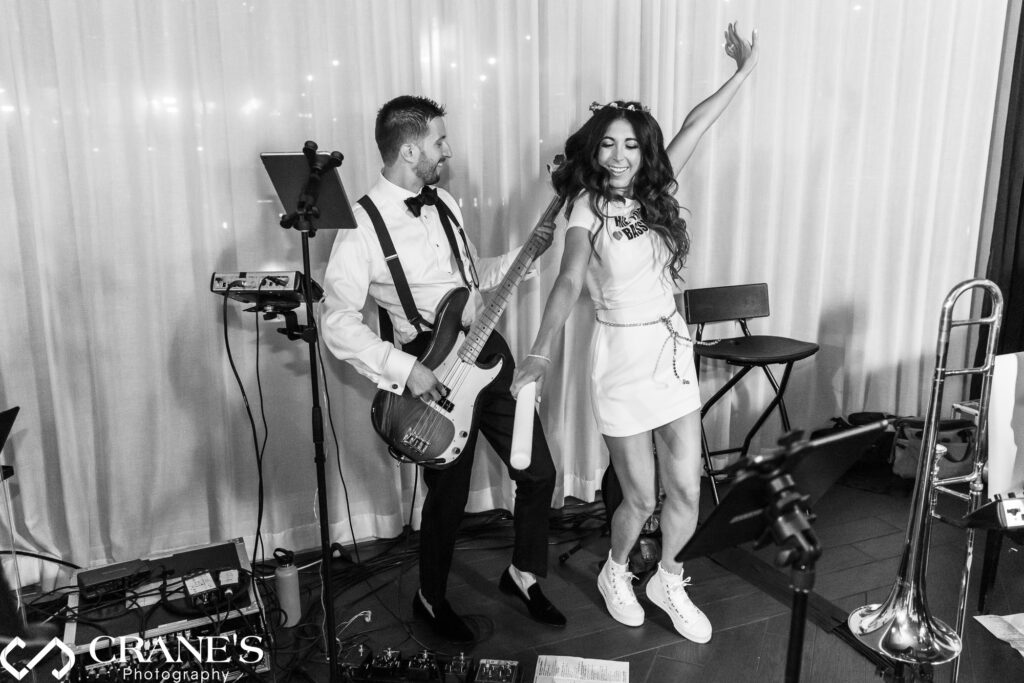 The bride dances with her groom as he plays guitar with the band during their wedding reception at RPM Events in Chicago.