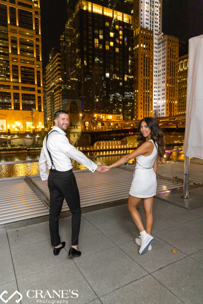 A nighttime wedding portrait on the terrace outside RPM, featuring the bride and groom with the city river in the background.