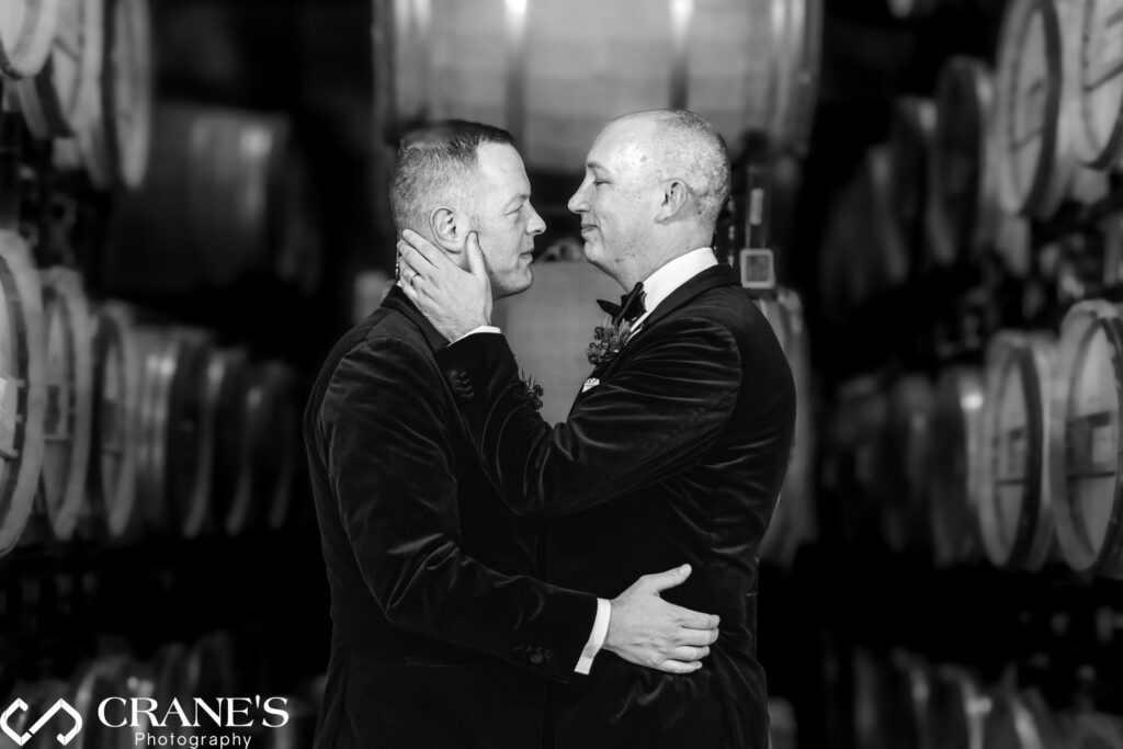 Intimate wedding photo capturing a tender moment between a gay couple in the Barrel Room at Chicago Winery.