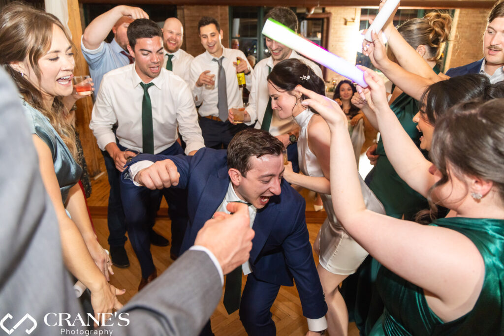 Bride and groom dancing together on the dance floor during a lively wedding reception at the Skyline Loft at Bridgeport Art Center.