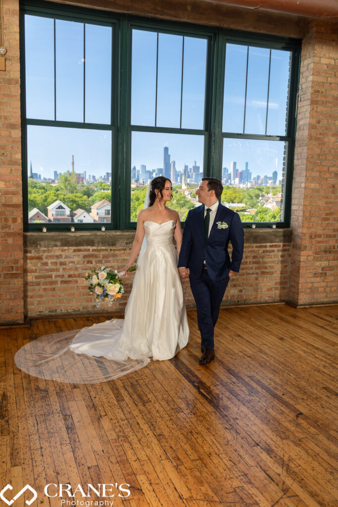 Bride and groom pose for a wedding photo at the Skyline Loft with the city in the background.