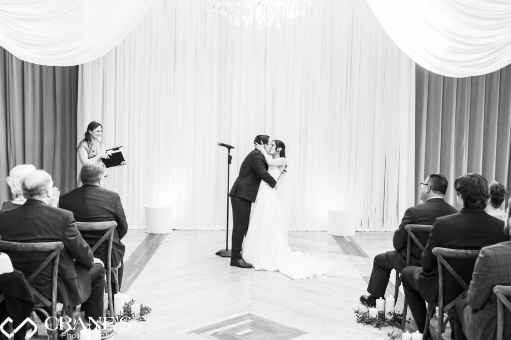 Bride and groom share their first kiss as a married couple during their wedding ceremony at the Skyline Loft at Bridgeport Art Center.
