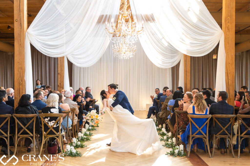 Bride and groom share a kiss at the end of the aisle, just after their wedding ceremony at The Skyline Loft at Bridgeport Art Center in Chicago.